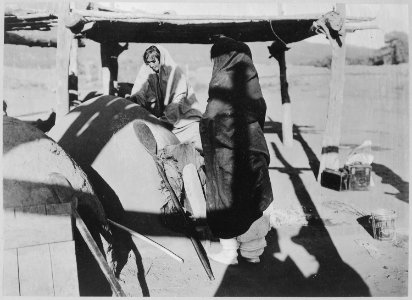 Two Taos women baking bread in outside oven, New Mexico, 1916 - NARA - 519166 photo