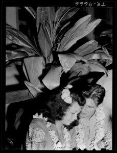 U.S. Navy pilot and date stand under tropical vegetation at Glen Innis Rest Home in New Zealand. - NARA - 520964