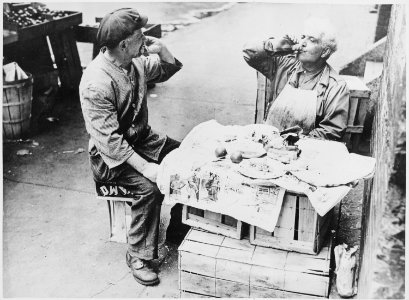 Two street vendors taking time out for lunch at a makeshift table of wooden crates covered with newspaper, 08-1946 - NARA - 541909