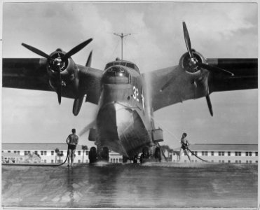 Twin-engine patrol bomber seaplane is hosed down after it was hauled up ramp at Naval Air Station in Banana River... - NARA - 520919