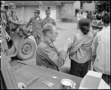 United States Air Force Captain John R. Vydareny, vaccinates a Vietnamese woman against plage during a MEDCAP visit... - NARA - 542310