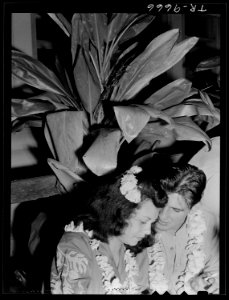 U.S. Navy pilot and date stand under tropical vegetation at Glen Innis Rest Home in New Zealand. - NARA - 520964