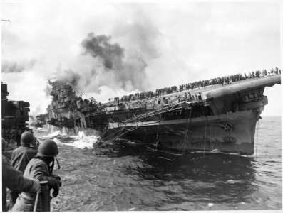 USS SANTA FE lays alongside of USS FRANKLIN rendering assistance after carrier had been hit and set afire by a... - NARA - 520656