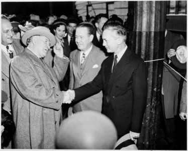 Vice President-elect Alben W. Barkley shakes hands with James V. Forrestal, with others looking on. - NARA - 199940