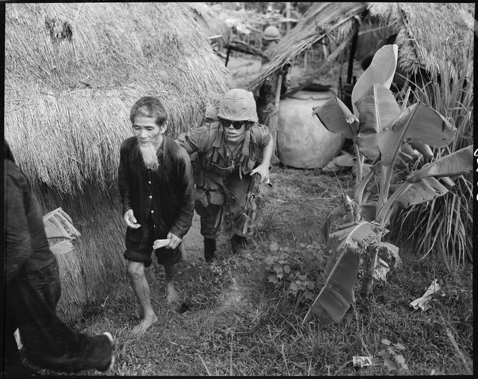 Vietnam....A Marine from 1st Battalion, 3rd Marines, moves a Viet Cong suspect to the rear during a search and clear... - NARA - 532431