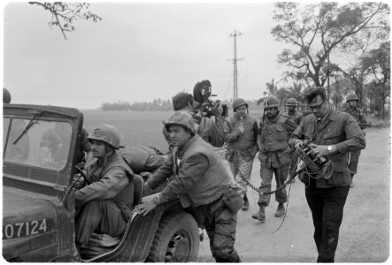 Vietnam. Walter Cronkite and a CBS Camera crew use a jeep for a dolly during an interview with the commanding officer... - NARA - 532454