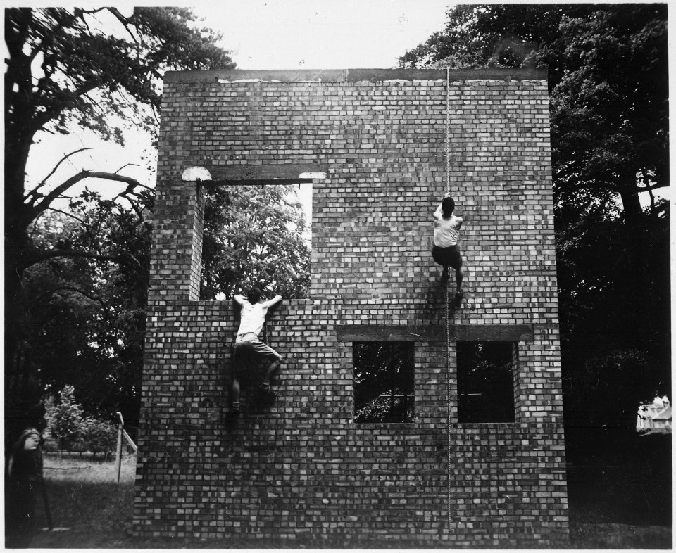 Two Jeds scale brick wall in training exercises. Milton Hall, England, circa 1944., 1943 - 1944 - NARA - 540065