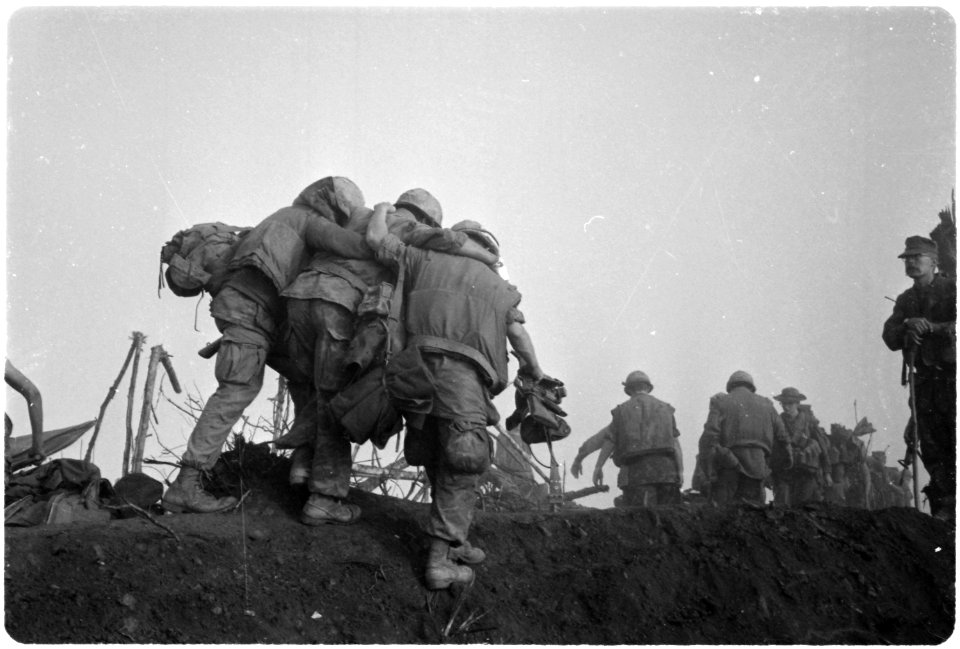 Vietnam....A Marine is helped to an evacuation point by two buddies after he was wounded during an enemy probe of his... - NARA - 532463