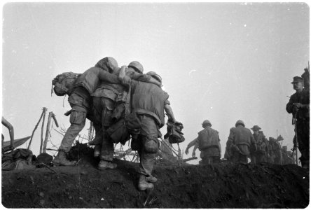 Vietnam....A Marine is helped to an evacuation point by two buddies after he was wounded during an enemy probe of his... - NARA - 532463