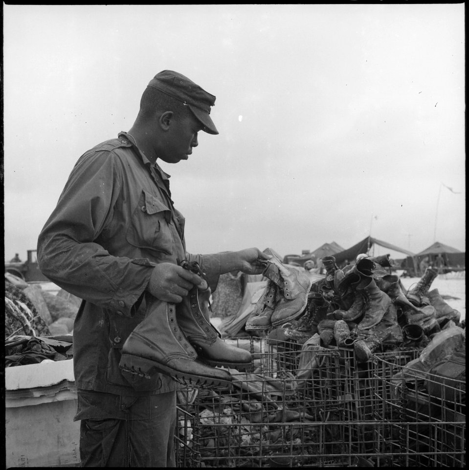 Vietnam....Private First Class Chris Banks, 3rd Shore Party Battalion, trades in a pair of ruined boots for a new... - NARA - 532438