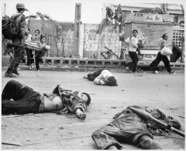 With fear and apprehension showing on their faces, and at the urging of South Vietnamese troops, women and children load - NARA - 541844 photo