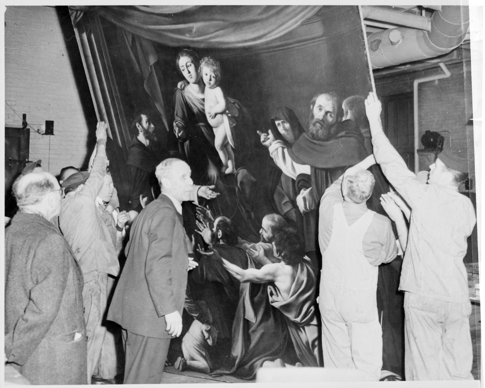 Workmen at the Metropolitan Museum of Art, New York, uncrating The Madonna of the Rosaries, a painting by Caravaggio o - NARA - 541883