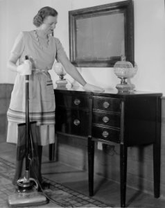 Woman dusting and using a vacuum photo