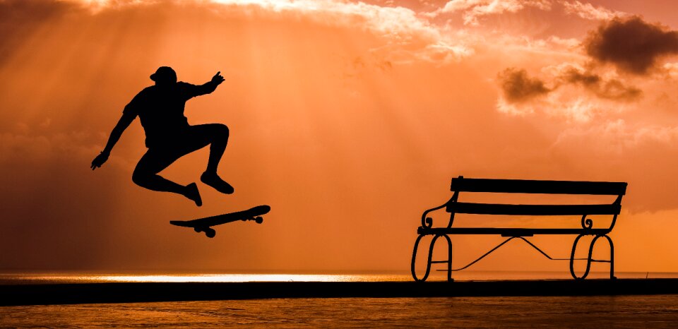 Skateboarder jump sunset