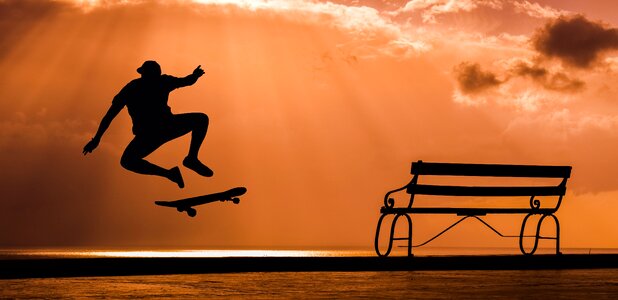 Skateboarder jump sunset photo