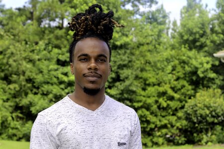 Man bun young man in yard young man outside