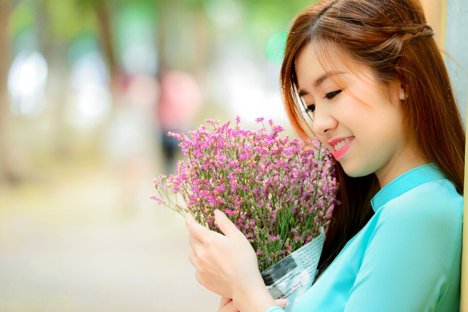 Girl long coat smell the flowers photo