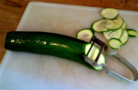courgette on a chopping board with vegetable peeler