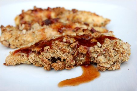 Chicken tenders covered in breadcrumbs, flour, nutmeg, orange zest and pecans. Sauce topping created with maple syrup, honey barbecue sauce, navel orange, and extra virgin olive oil.