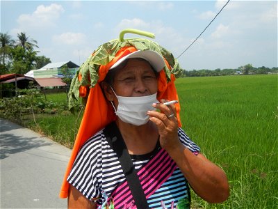 Smoking women with carica papaya leaves hat