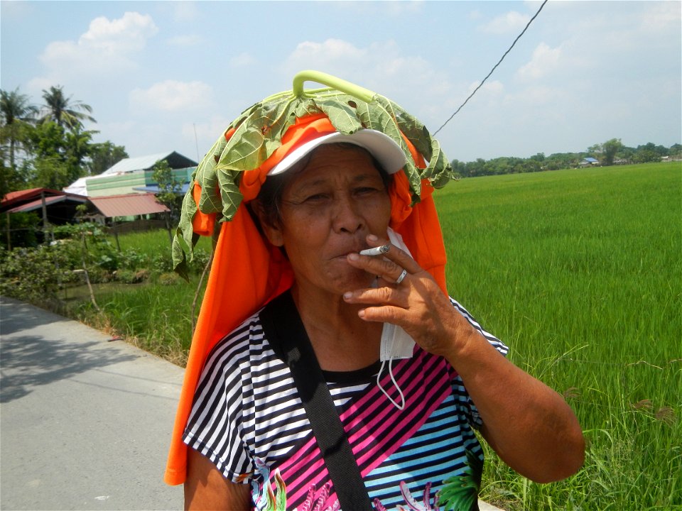 Smoking women with carica papaya leaves hat
