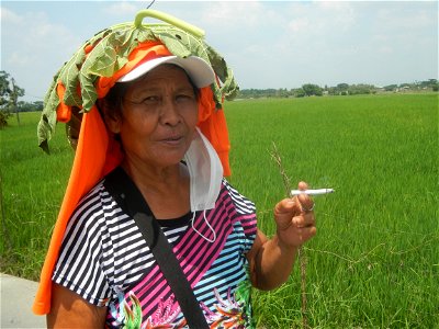 Smoking women with carica papaya leaves hat