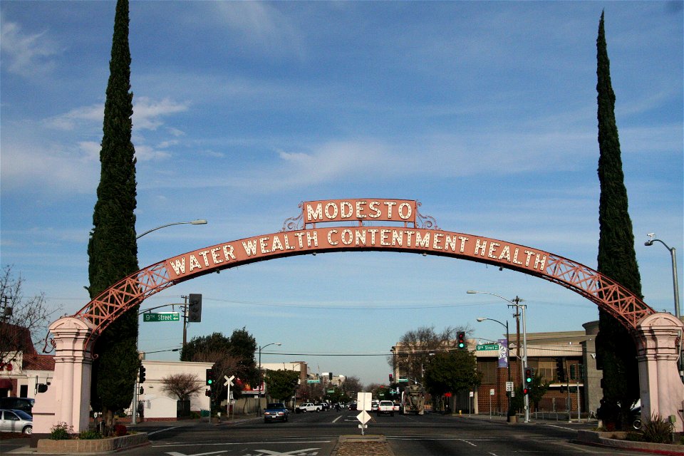 The Modesto Arch, first erected in 1912, by a level crossing in Modesto, north central California. The slogan is the city's motto: "Water, wealth, contentment, health".