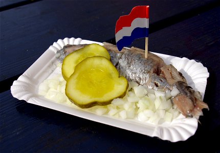 Hollandse Nieuwe mit uitjes (fein gehackte Zwiebeln) und zuur (de:Gewürzgurke) Nederlands: Hollandse Nieuwe met uitjes en zuur photo