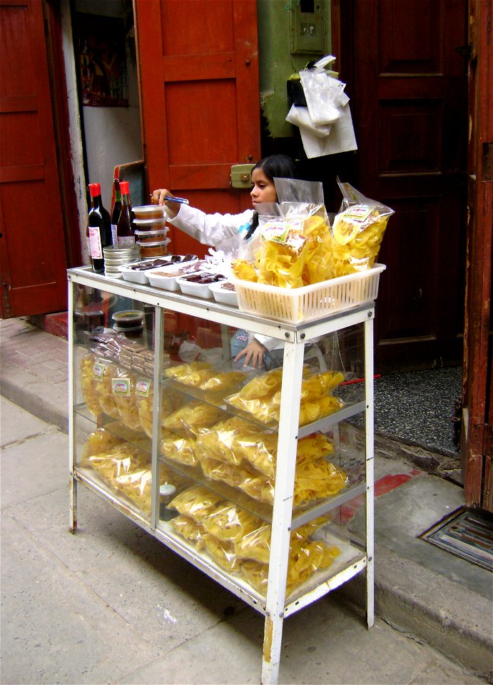 A girl selling sweets, chifles, honey, natillas, dulce de membrillo, manjarblanco and algarrobina in Comercio Street. Catacaos, Piura, Peru.