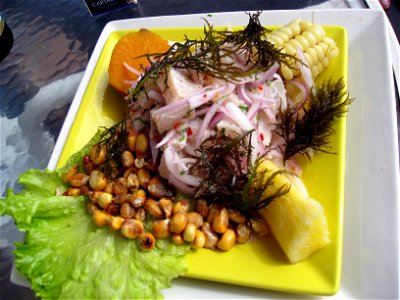 Fish Ceviche as served in La Punta - Callao (Peru). Note presentation with choclo (maize), yuca (cassava), cancha (toasted maize) and camote (sweet potato), covered with yuyo (sea weed).