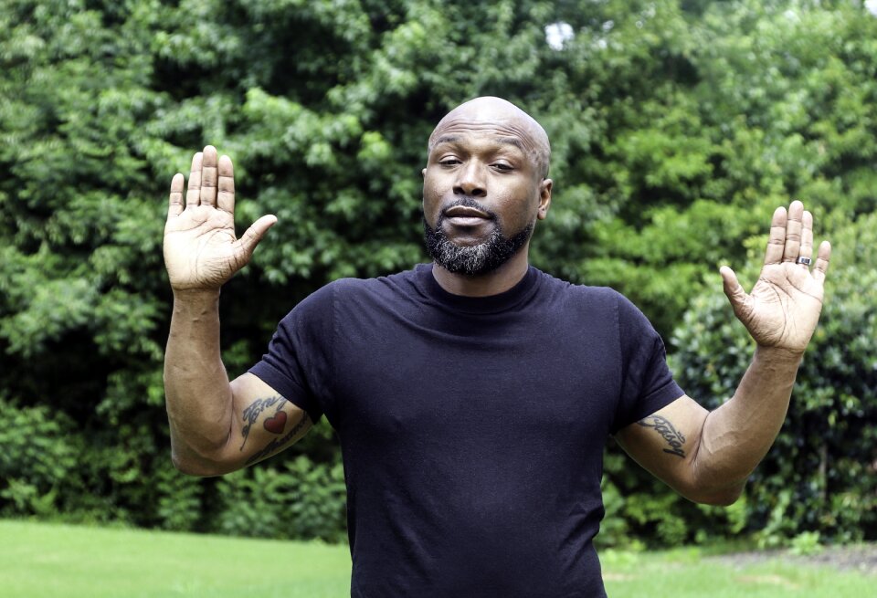 Hands up middle-aged man man with tattoos