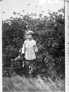 A young Chinese man dressed in white European-style dress with hat.