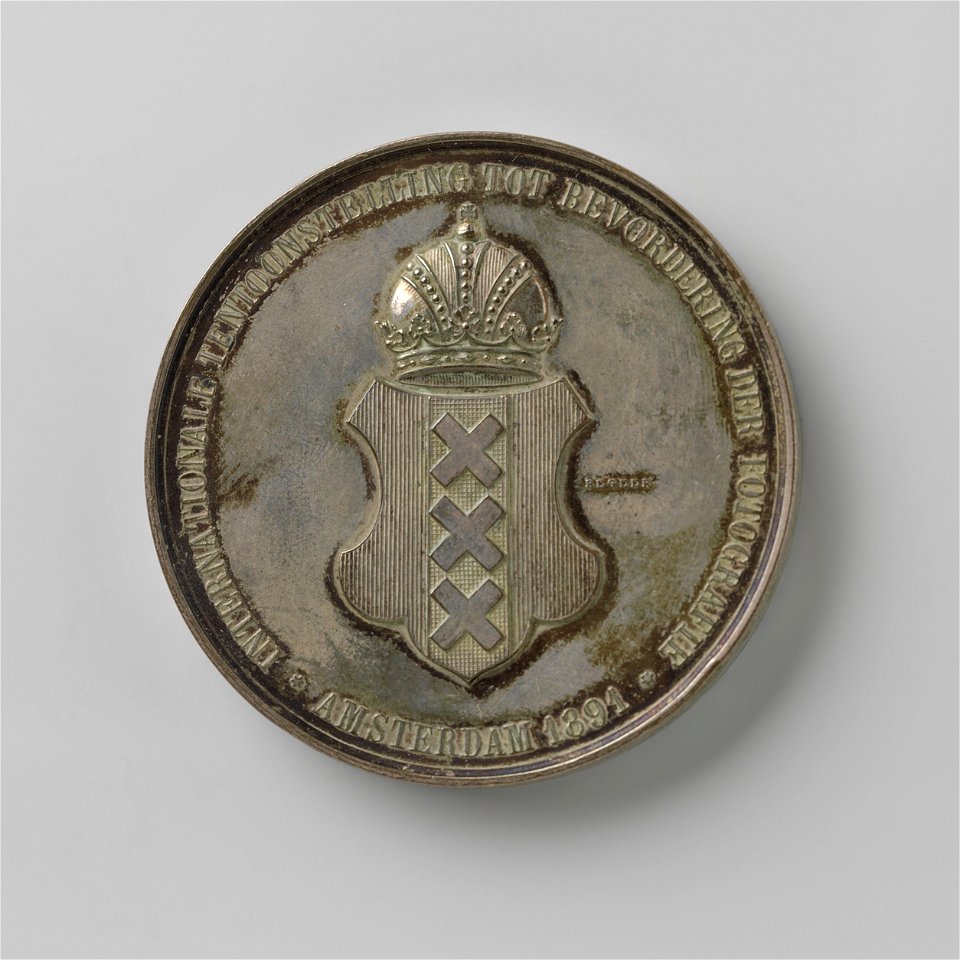 IdentificatieTitel(s): Internationale tentoonstelling tot bevordering der fotografie Amsterdam 1891Objecttype: prijspenning Objectnummer: NG-2014-22-1Omschrijving: Penning van zilver. Voorzijde pennin