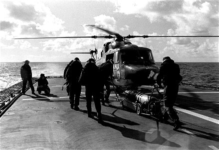 Crewmen move a Mark 46 torpedo across the flight deck of the West German frigate FGS KARLSRUHE (F 212) to load it aboard a waiting Mark 88 Lynx helicopter during FLEET EX 1-90