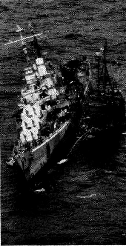 The U.S. Navy fleet ocean tug USS Zuni (ATF-95) stands by the torpedoed light cruiser USS Reno (CL-96) in the Philippine Sea. Reno was listing 16°.