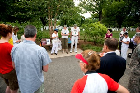 From the left, Teresa Lim, Cindy Wackerbarth and Paul Wackerbarth, all volunteers with Monarch Teacher Network, give remarks to nearly 30 attendees of a butterfly release in Arlington National Cemeter photo