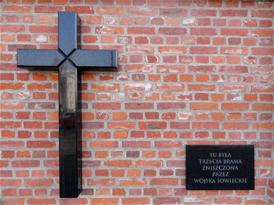 Krzyż i tablica na murze Cmentarza Powązkowskiego koło skrzyżowania ulic Powązkowskiej i Piaskowej w Warszawie, upamiętniające lokalizację dawnej III bramy. Inskrypcja Tu była trzecia brama zniszczona