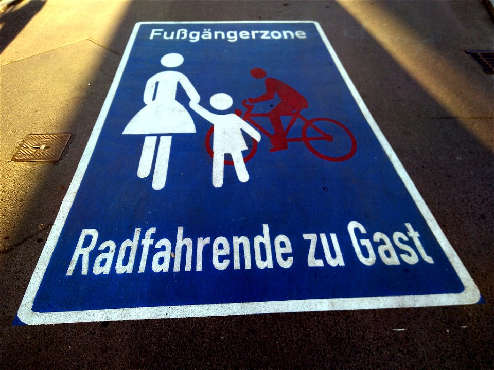 Roadway pictogram "Pedestrian zone cyclists as guests" in the pedestrian zone in Waldemarstraße in Berlin-Kreuzberg, Germany.