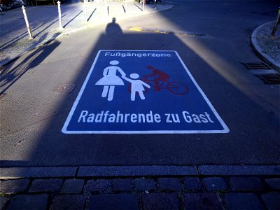 Roadway pictogram "Pedestrian zone cyclists as guests" in the pedestrian zone in Waldemarstraße in Berlin-Kreuzberg, Germany.