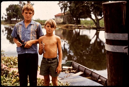 BOYS WITH AIRGUN AND BIRD. THESE FISHERMAN'S SONS LIVE IN BAYOU GAUCHE, DEEP IN THE WETLANDS OF LOUISIANA