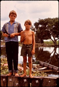 BOYS WITH AIRGUN AND BIRD. THESE FISHERMEN'S SONS LIVE IN , DEEP IN THE WETLANDS OF LOUISIANA.