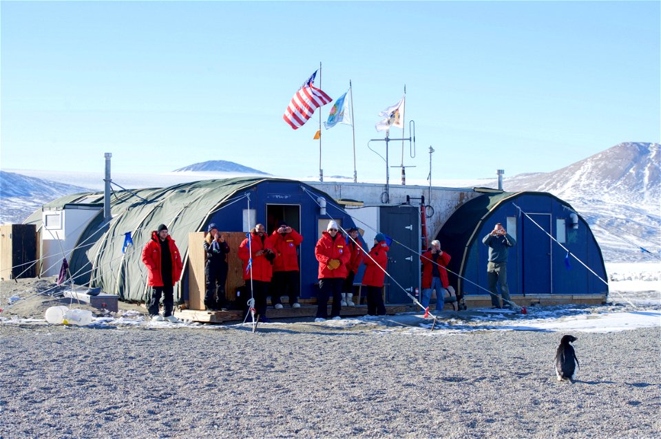 U.S. Secretary of State John Kerry and his traveling party look at an Adélie penguin after it approached them in Antarctica on November 11, 2016, as the Secretary conducted a helicopter tour of U.S. r