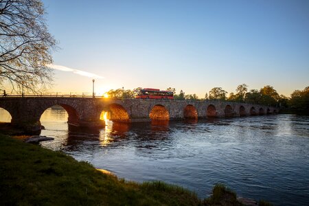 Bus stone arch bridge sunset