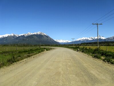 Dirt road mountains snow capped photo
