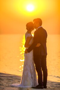 Bride groom kiss sunset photo