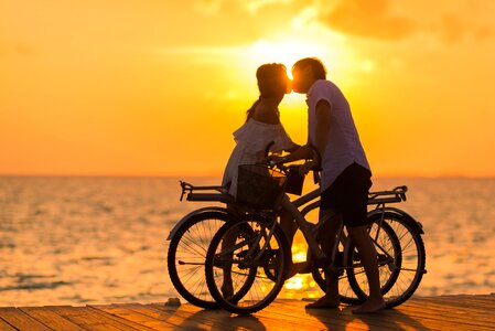 Couple kiss bicycle sunset photo
