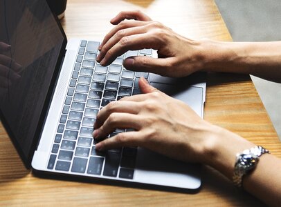 Laptop computer typing hands photo