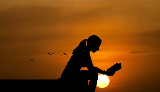 Sunset woman reading book