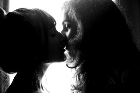 Two women kiss