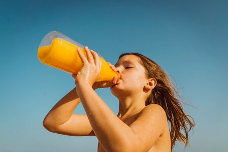 Girl drinking orange juice photo